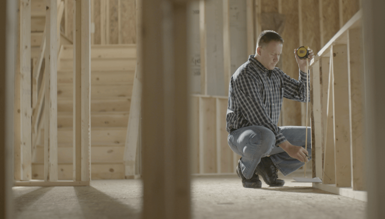 man measuring in a construction area